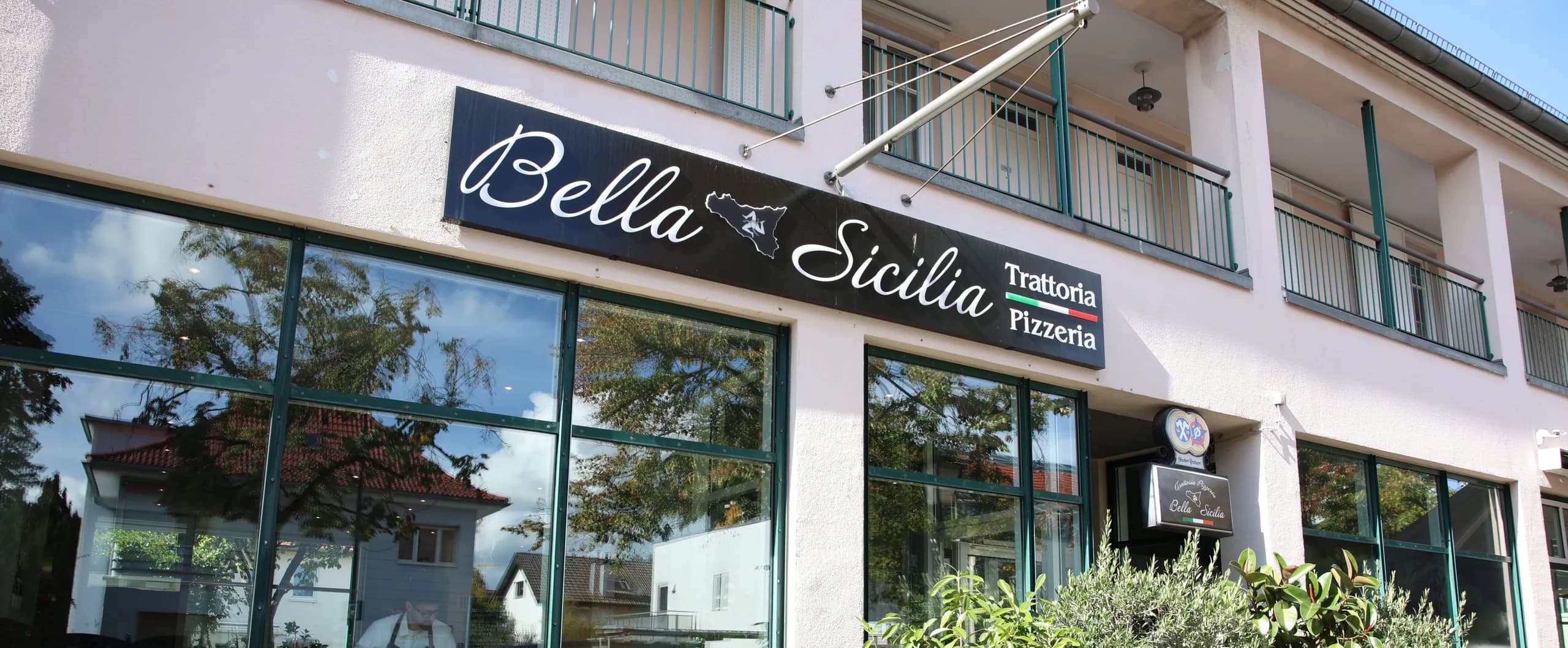 Die Fassade des Bella Sicilia mit dem Schild Trattoria Pizzeria