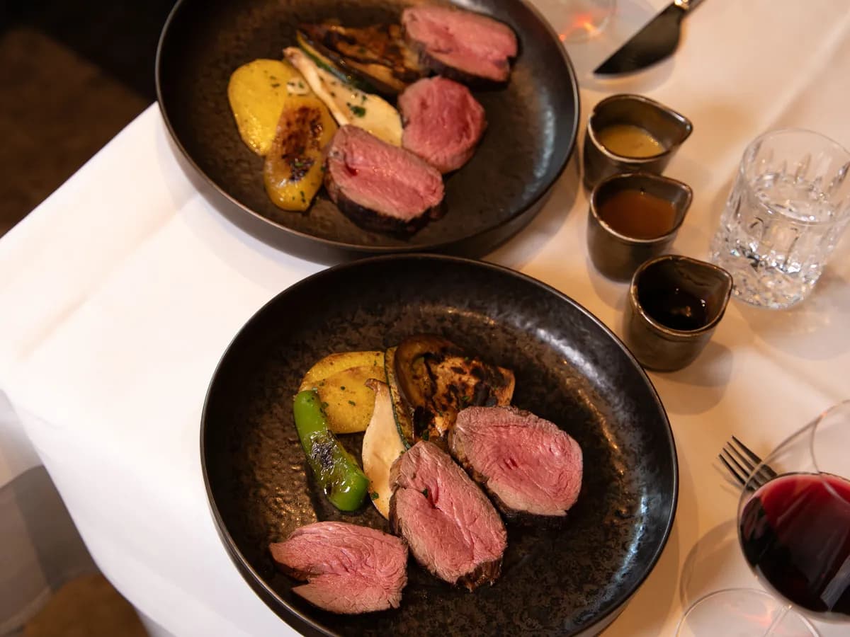Zwei Teller mit rosa gebratenem Fleisch und Gemüse